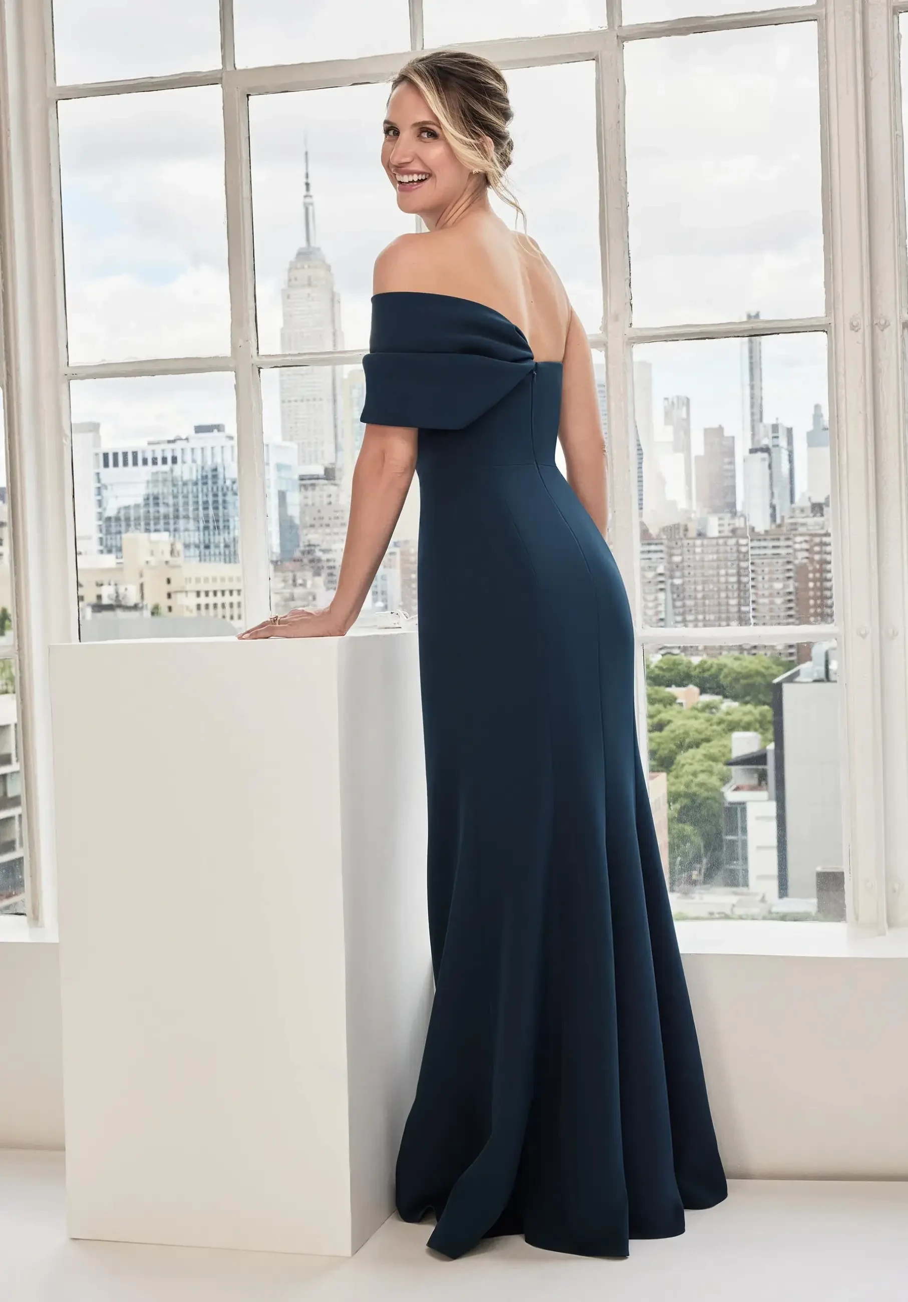 model is wearing a navy one shoulder evening gown