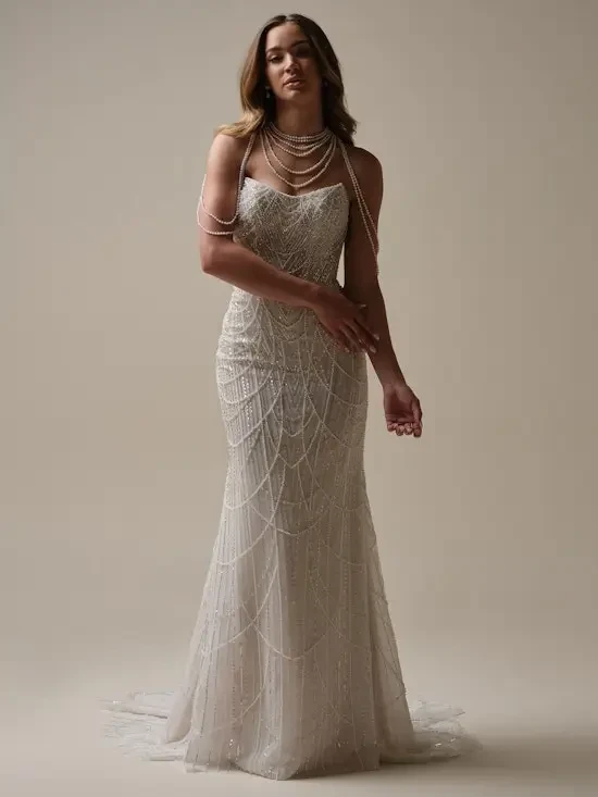 model is wearing a lace fit and flare wedding dress draped in pearls