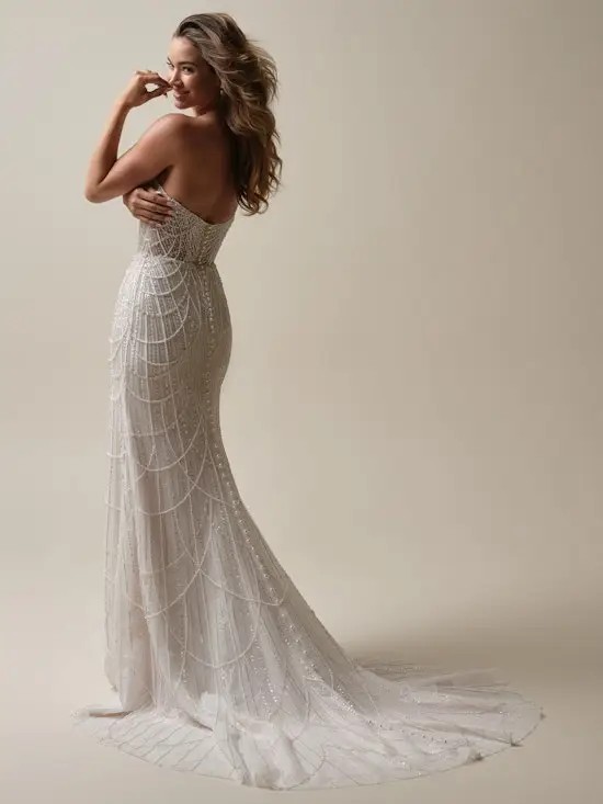 Model is wearing a fit and flare wedding dress with draped pearls by maggie sottero