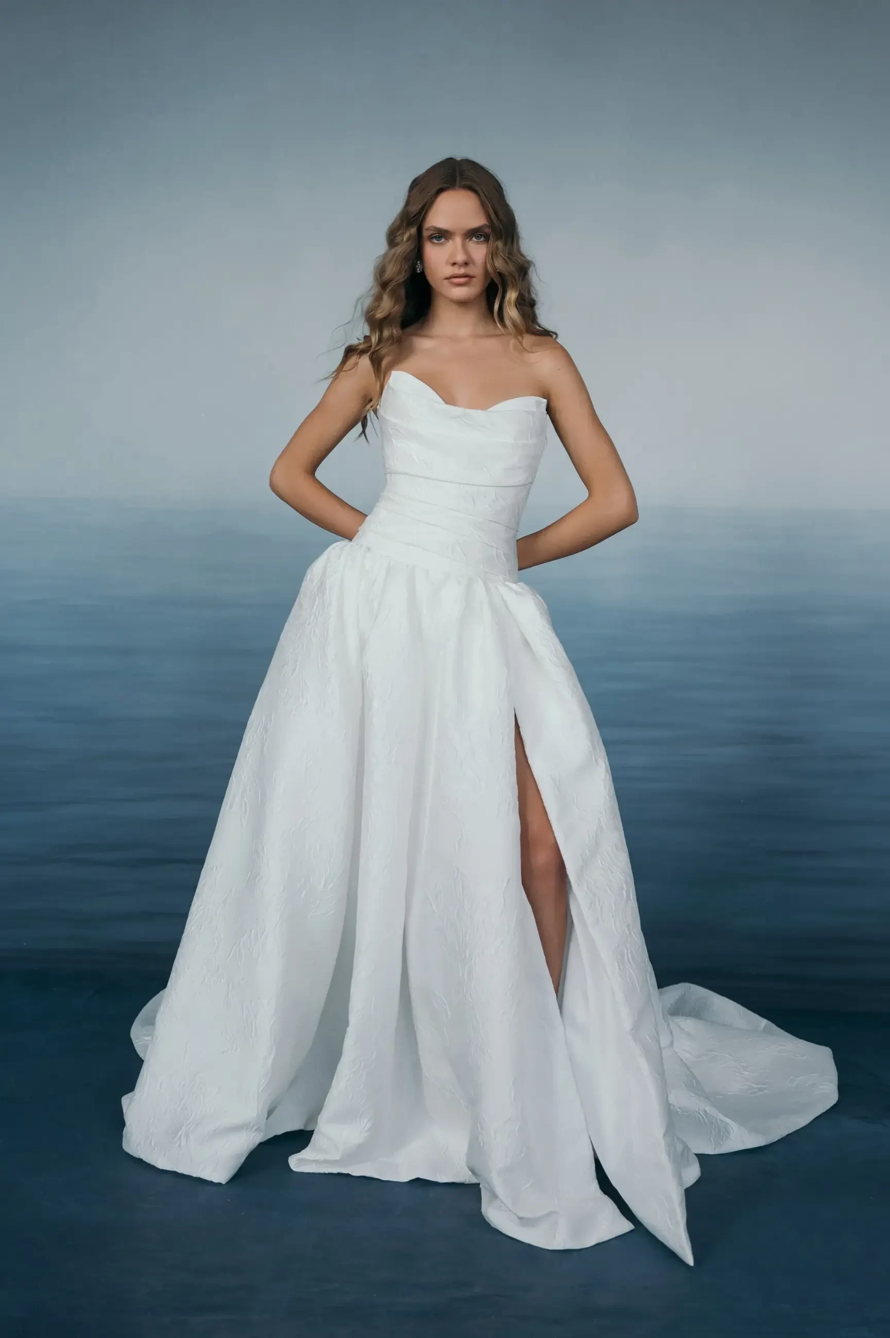 model is wearing a strapless a-line bridal dress with a slit