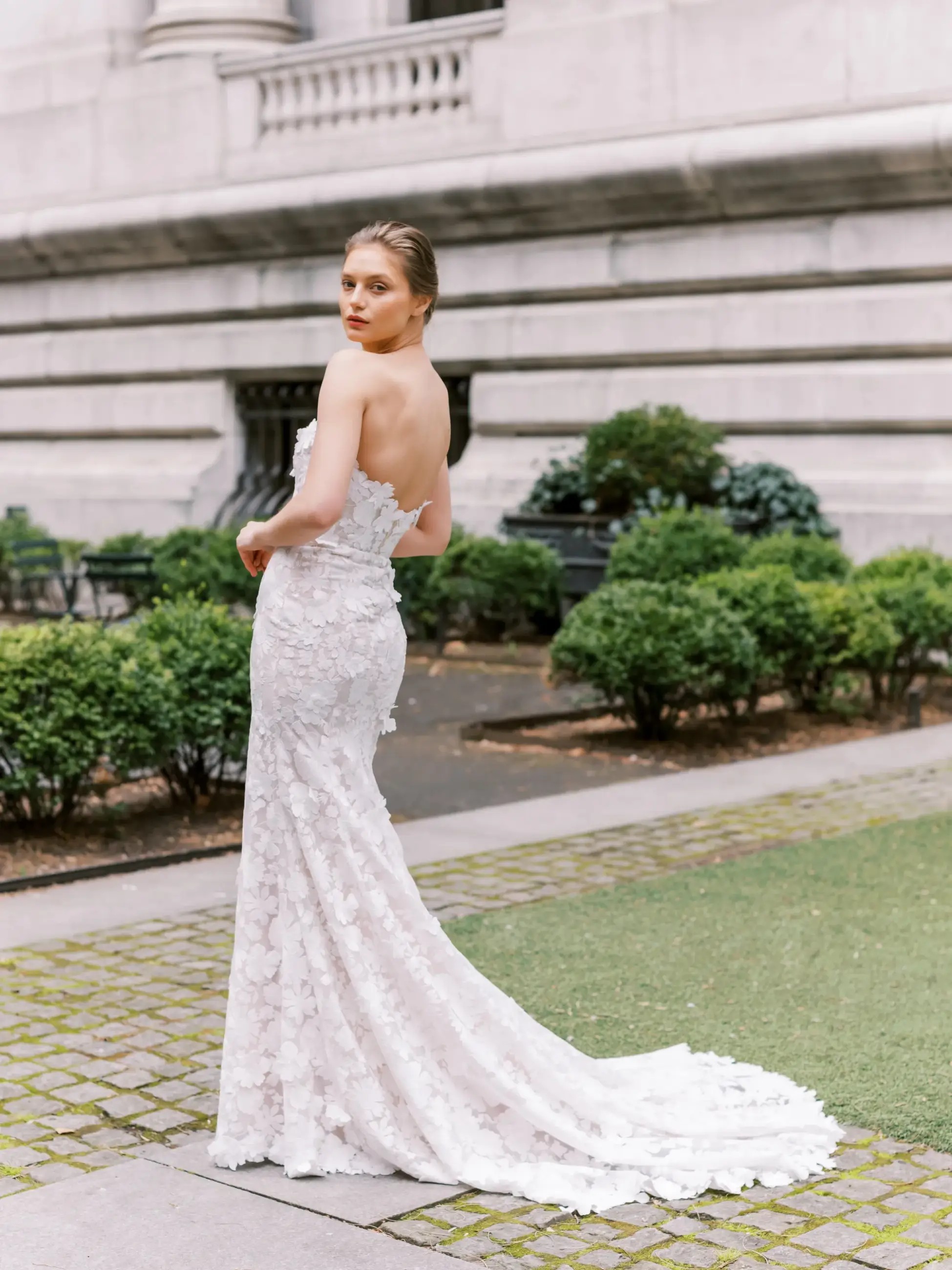 Model is wearing a strapless wedding dress that has 3D embroidered lace by beccar