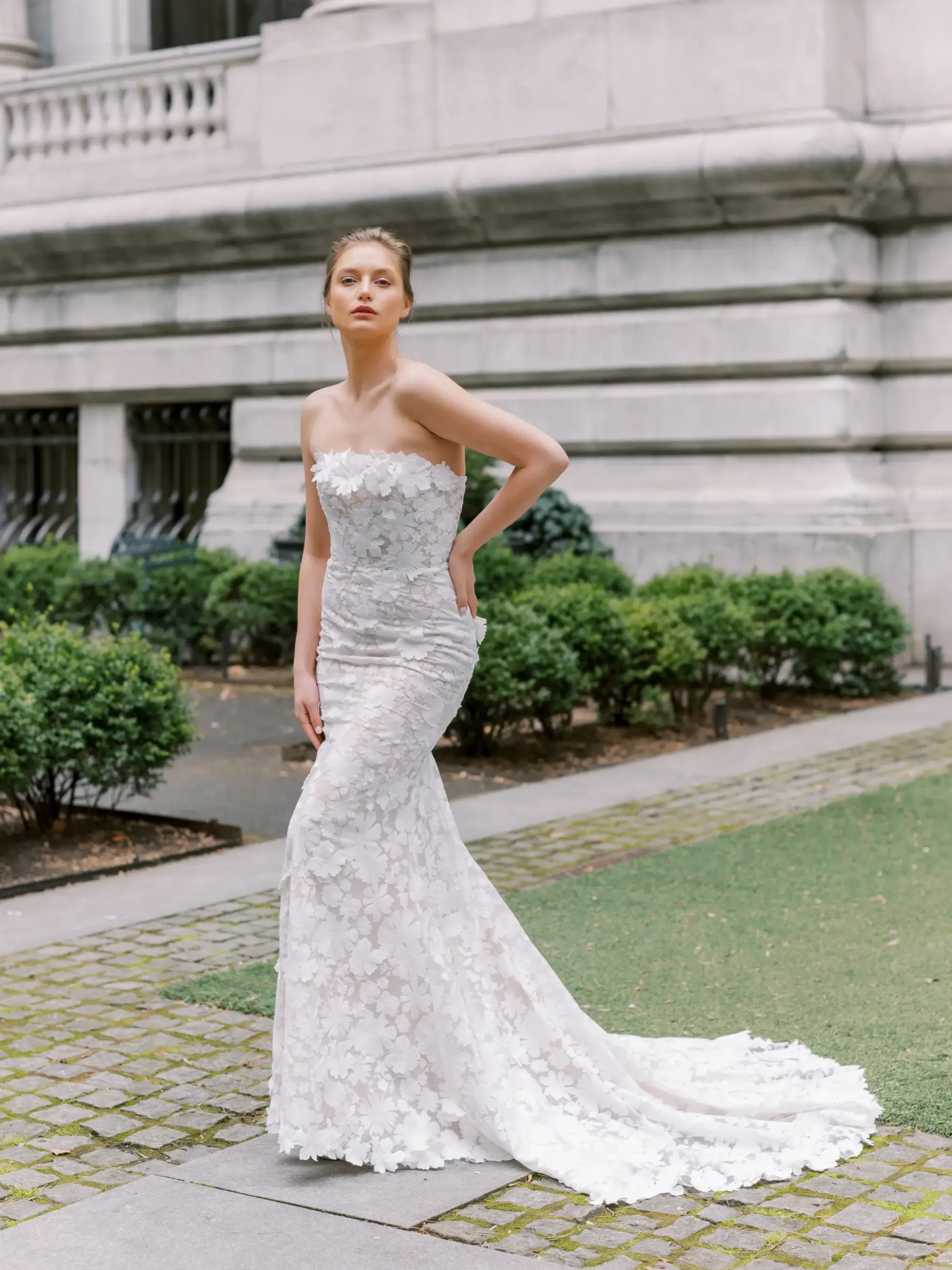 Model is wearing a strapless wedding dress that has 3D embroidered lace by beccar