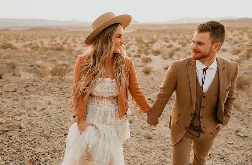 Сouple wearing a white gown and a brown suit