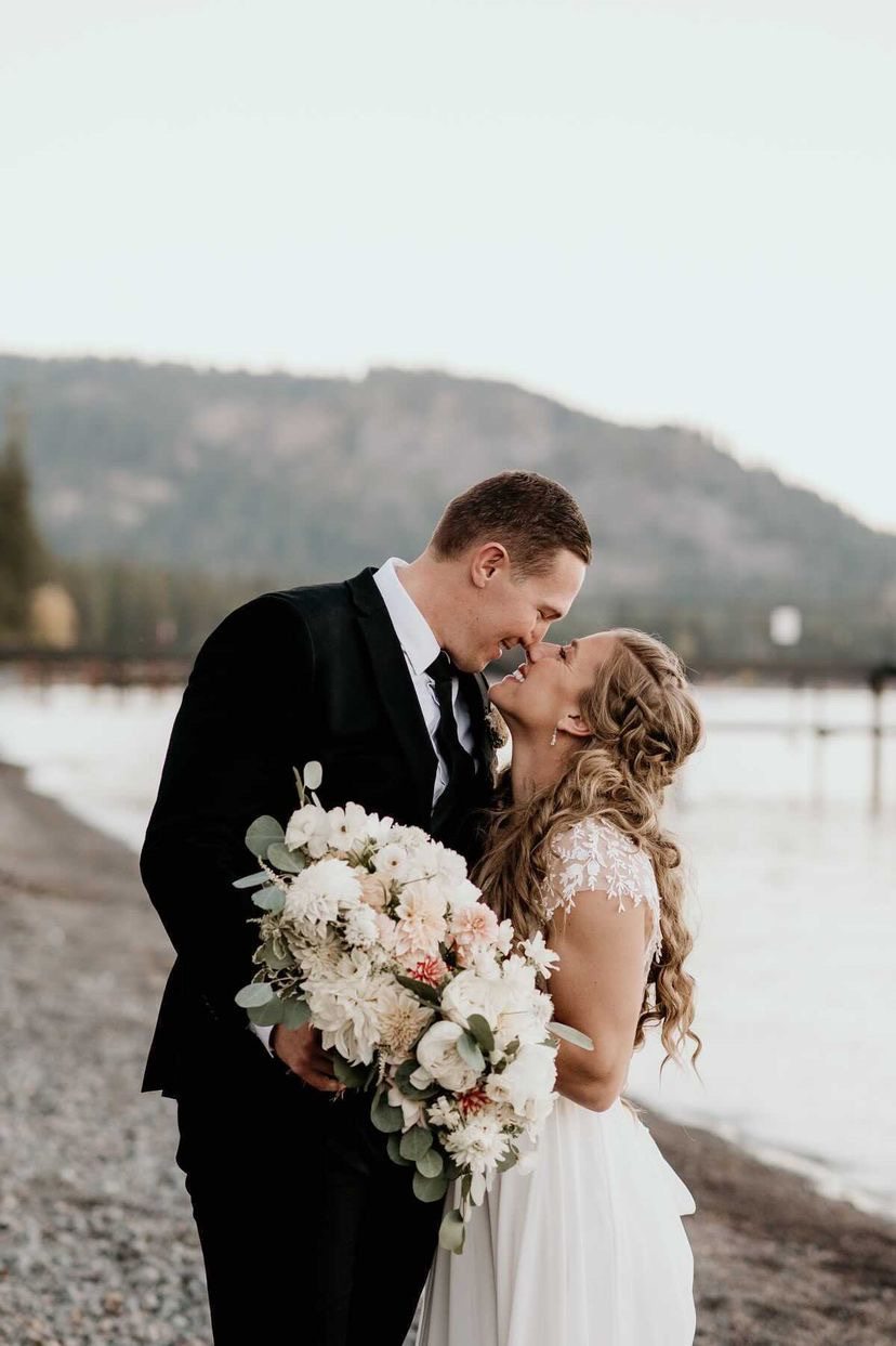 Сouple wearing a white gown and a black suit on the beach
