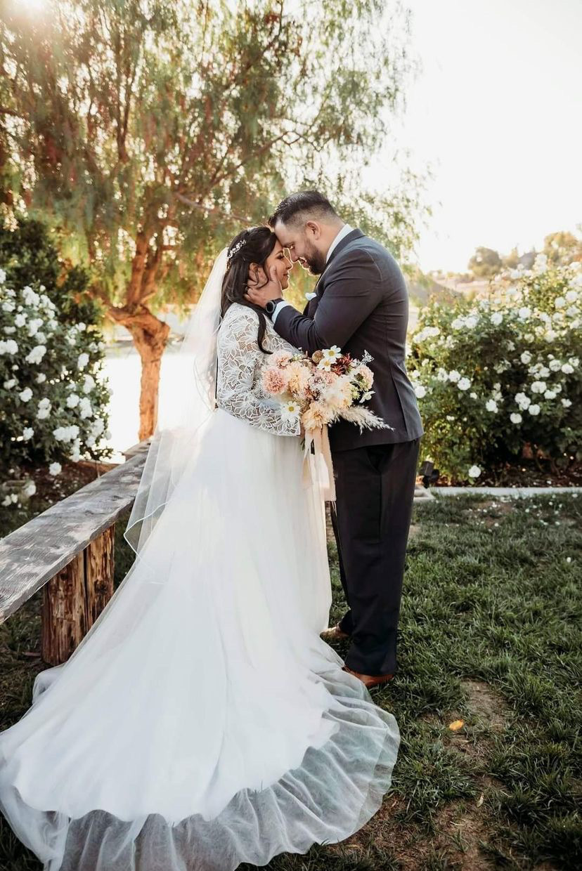 Сouple wearing a white gown and a black suit on the grass