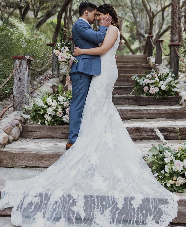 Сouple wearing a white gown and a blue suit on the stairs