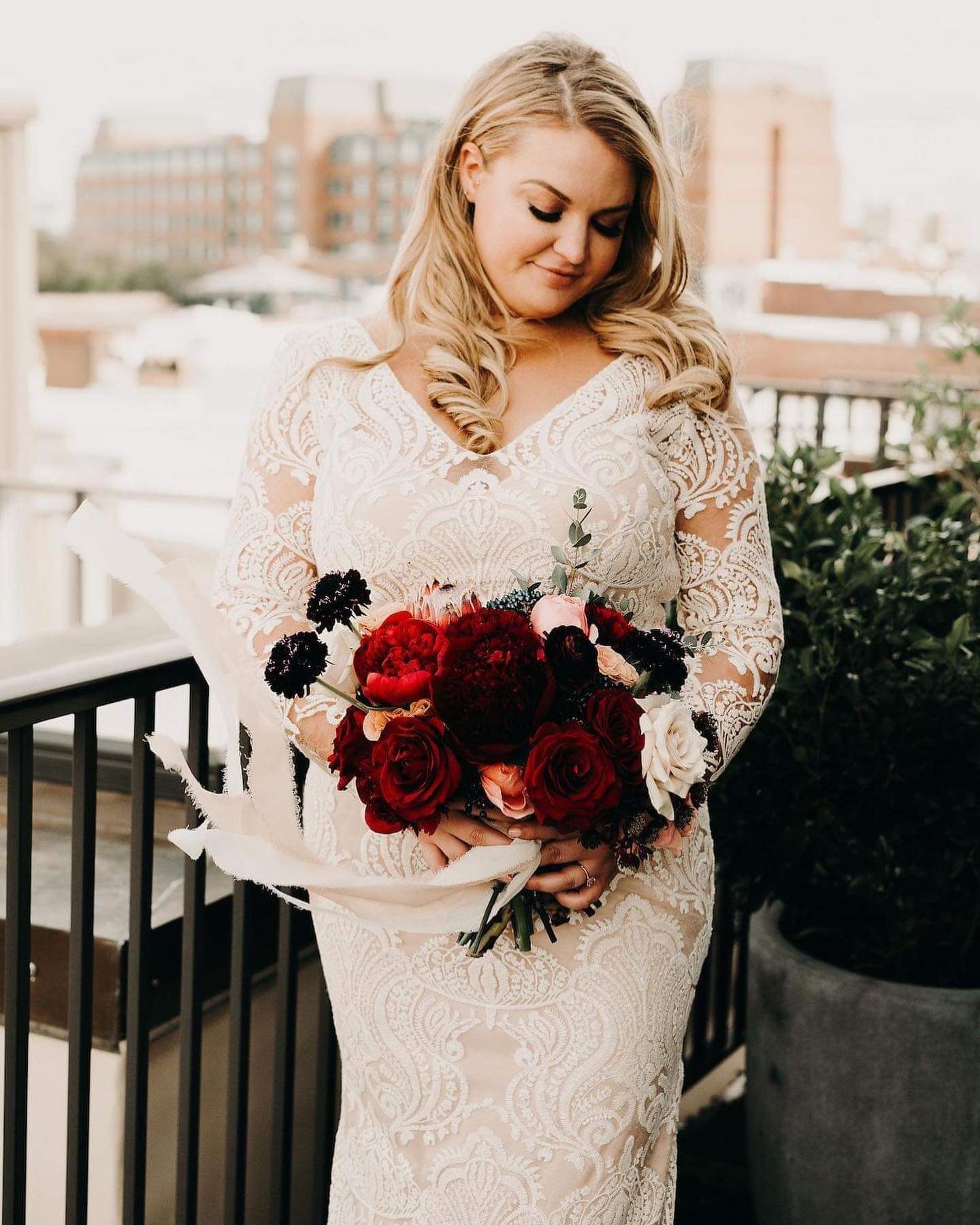 Model wearing a white gown with a red flowers