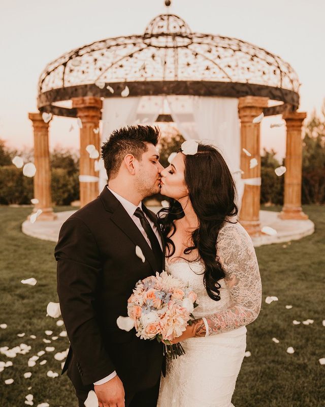 Kissing couple wearing a white gown and a black suit