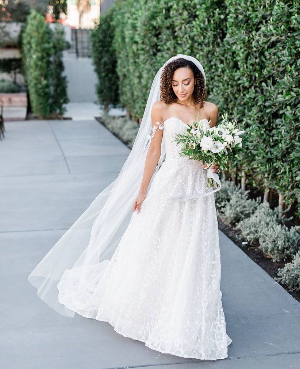 Model wearing a white gown with a flowers