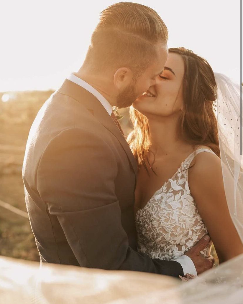 Kissing couple wearing a white dress and a black suit