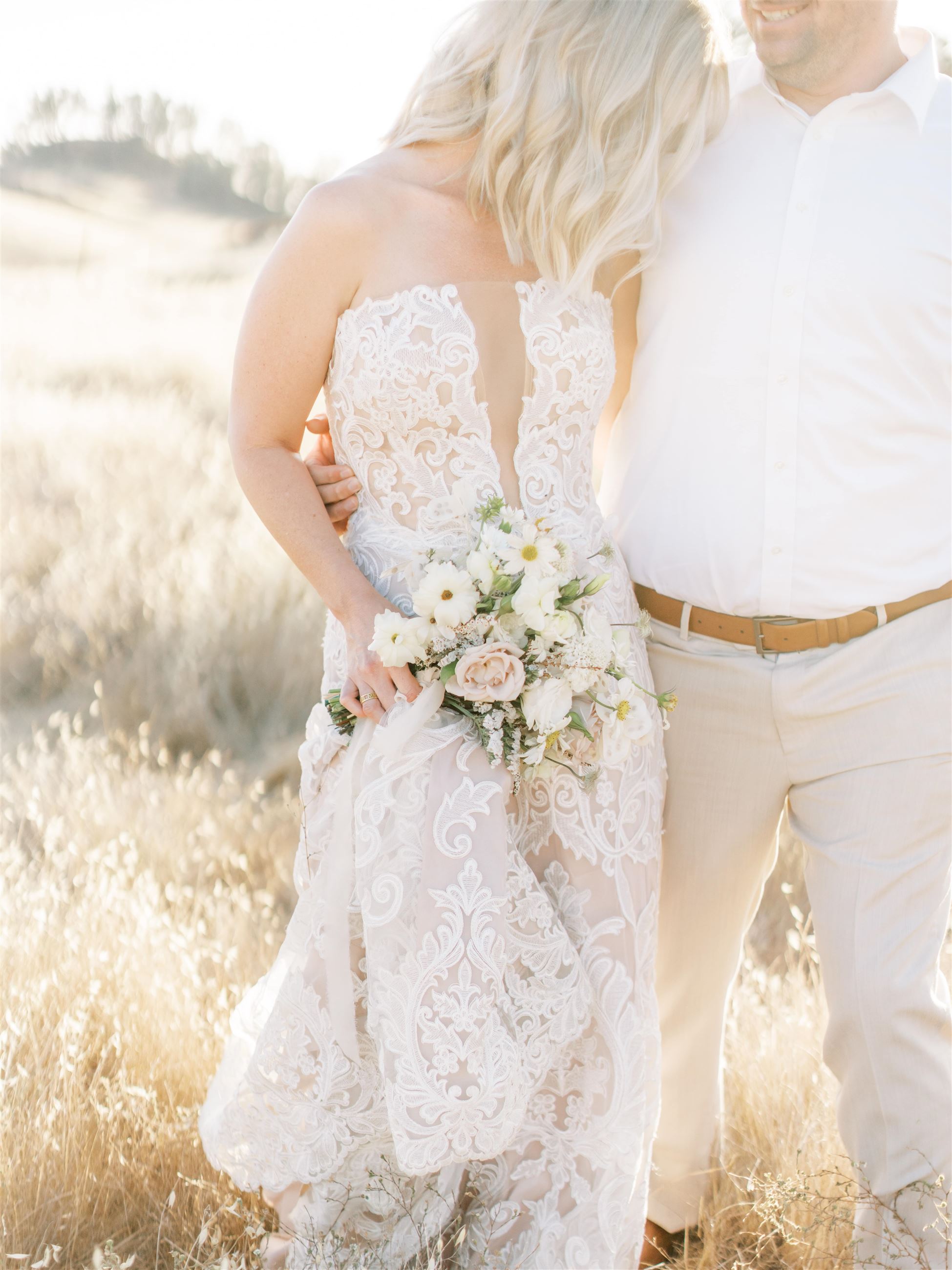 Сouple wearing a white gown and a white suit