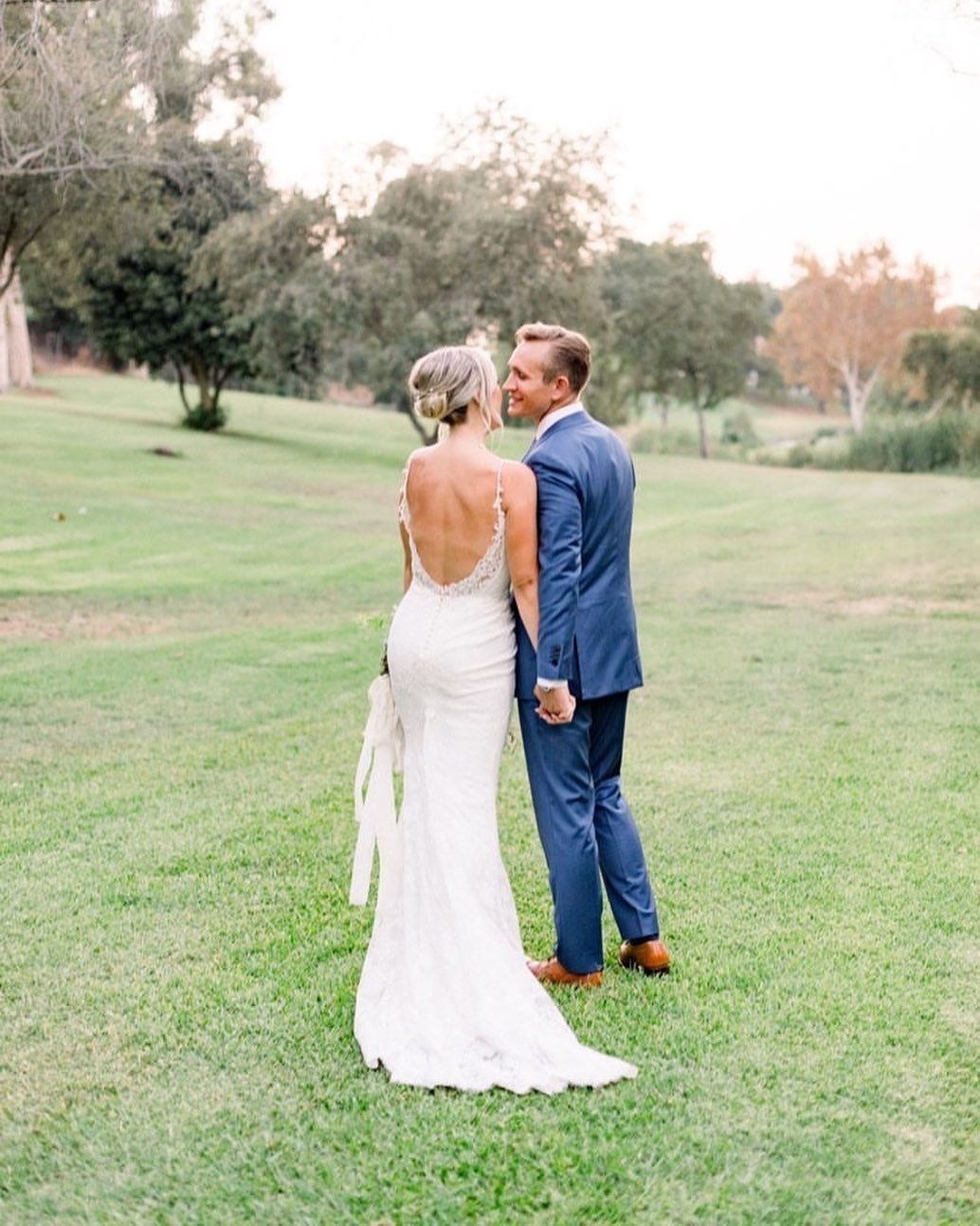 Сouple wearing a white gown and a blue suit on the grass