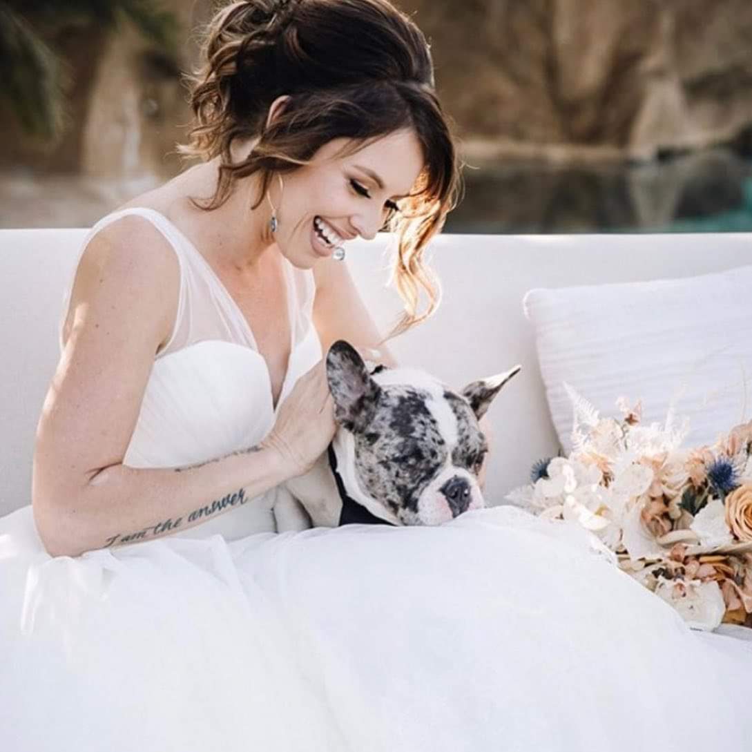 Model wearing a white gown with a dog